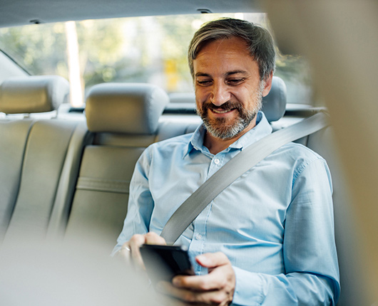 Man in the back of a cab on his phone